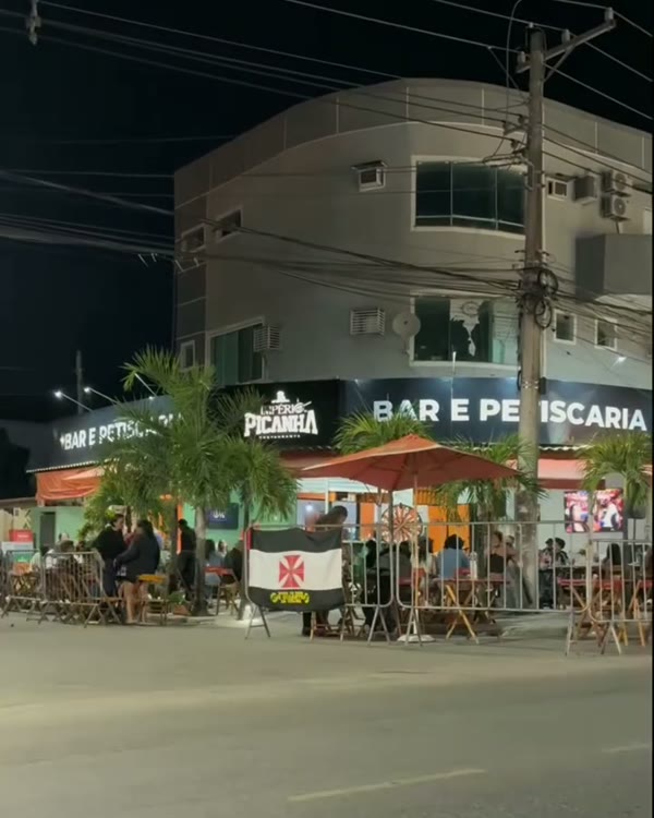 Fachada da choperia à noite, com o letreiro aceso